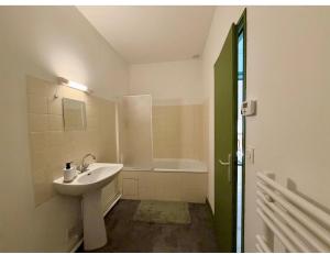 a bathroom with a sink and a bath tub at Appartement Martell in Cognac