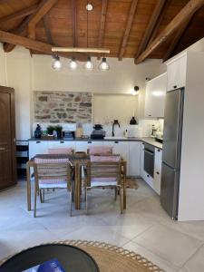 a kitchen with a table with chairs and a refrigerator at Koumara Stone House in Koútsi