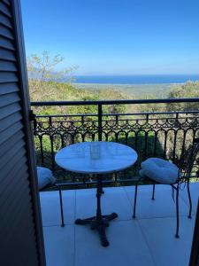 a table and chairs on a balcony with the ocean at Koumara Stone House in Koútsi