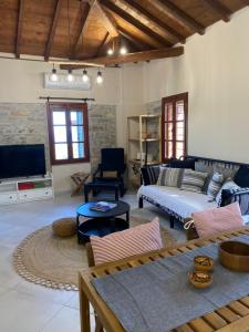 a living room with a couch and a tv at Koumara Stone House in Koútsi
