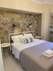 a bedroom with a large bed and a stone wall at Koumara Stone House in Koútsi +3 photos