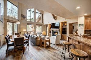 a kitchen and living room with a table and chairs at Elkhorn Lodge, A Vail Resorts Property in Avon