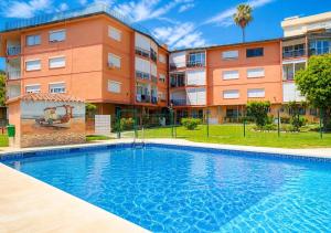a swimming pool in front of a building at Estudio con piscina y jardines a 2 min de la playa - Fuengirola in Fuengirola