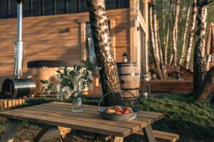 a wooden picnic table with a bowl of fruit on it at Skryta Chata Ojców in Smardzowice