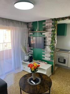 a living room with a vase of flowers on a table at Sky Apartment in Miramar