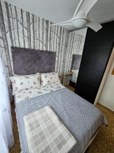 a bedroom with a bed and a wall with trees at Sky Apartment in Miramar