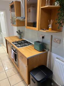 a kitchen with a stove and a trash can at Anglesey House in Burton upon Trent