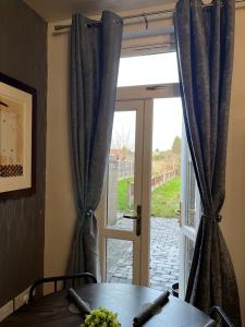 a glass door with a table in front of a window at Anglesey House in Burton upon Trent