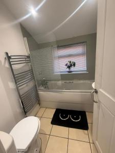 a bathroom with a toilet and a tub and a window at Anglesey House in Burton upon Trent +35 photos