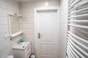 a white bathroom with a toilet and a sink at ALE WIDOKI Apartamenty Gościnne in Giebło +21 photos
