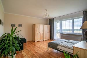a bedroom with a bed and a large window at ALE WIDOKI Apartamenty Gościnne in Giebło