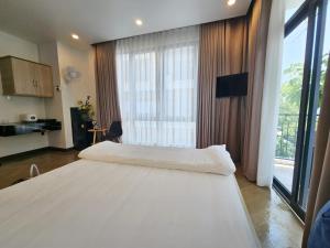 a bedroom with two beds and a large window at Serene Residence in Vientiane