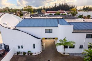 an aerial view of a white building with a blue roof at Te Awa Suites in Hamilton