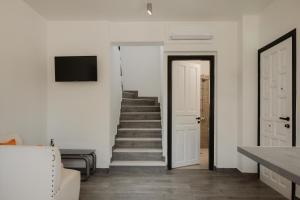 a stairway leading to a white room with a staircase at Mariu Canal d' Amour in Melíssia
