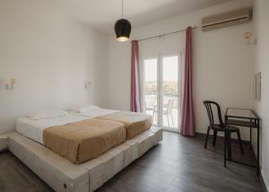 a bedroom with a bed and a table and a window at Mariu Canal d' Amour in Melíssia +28 photos