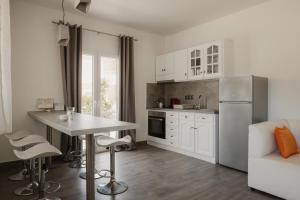 a kitchen with a table and a white refrigerator at Mariu Canal d' Amour in Melíssia