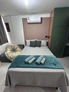 a bedroom with a bed with two remote controls on it at Flat Só Alegria in Cabedelo +17 photos