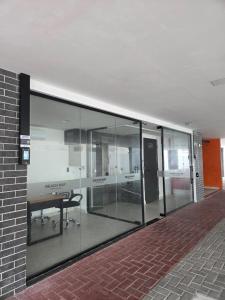 a glass wall in a building with a desk in it at Flat Só Alegria in Cabedelo