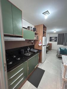 a small kitchen with a sink and a refrigerator at Flat Só Alegria in Cabedelo