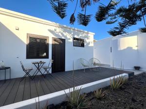 a wooden deck with chairs and a table on a house at Habitación de invitados Casa Lume in Tahiche