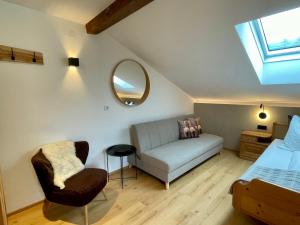 ein Dachzimmer mit Sofa und Spiegel in der Unterkunft Quartier 27- modern Apartment with Balcony & free parking in Tulfes