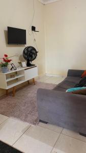 a living room with a couch and a tv at Casa Mobiliada 4 camas e 2 quartos in Juazeiro do Norte