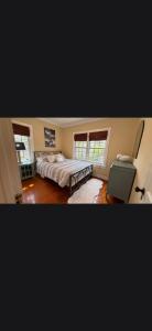 a bedroom with two beds and a desk and two windows at Casa de David from the 1920s Era in West Palm Beach