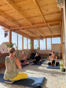 a group of people sitting in a yoga class at Sines Surfmaroc in Tamraght Ouzdar