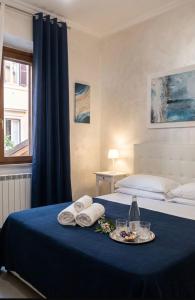 a bedroom with a blue bed with towels and a tray of food at Sabrina Airport in Fiumicino