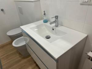 a white bathroom with a sink and a toilet at Camera vicino Ospedale Maggiore, Concerti e Aeroporto Bologna 60 mq in Bologna