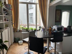 a kitchen with a table and chairs and a window at partie jasmin in Brussels