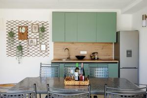 a kitchen with green cabinets and a table with chairs at Villa Kaplan Verde in Stolac