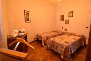 a hotel room with two beds and a table at Affittacamere Casa Sofia in Anghiari