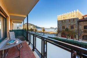 a balcony with a bench and a view of a building at Pensión Zarauz Playa in Zarautz