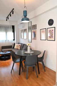 a dining room and living room with a black table and chairs at Apartment 84 in Donja Lastva +2 photos