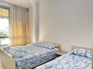 a bedroom with two beds and a window at Guest House Kasa Garden in Durrës