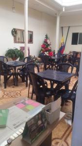 a room with tables and chairs and a christmas tree at Hotel casa inglesa in Buga