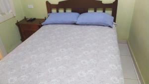 a bed with blue pillows on it in a room at Hotel casa inglesa in Buga