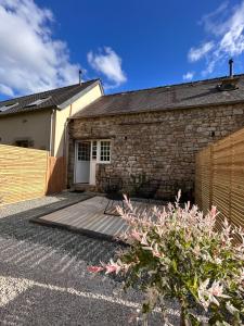 a house with a wooden deck in front of it at Ker Rev Home Gîte indépendant de charme en longère bretonne in Quimper