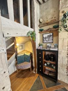 a small room with a bed and a chair and a cabinet at Le 16 authentique au cœur de la ville in Lisieux