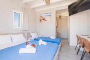 a living room with two beds and a table at Vivens Mykonos Studios & Suites in Ano Mera