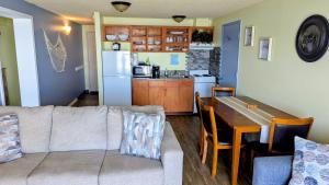 a living room with a couch and a table and a kitchen at Silver Surf Motel in Yachats