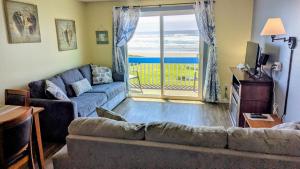 a living room with a couch and a view of the ocean at Silver Surf Motel in Yachats