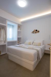 a white bedroom with a large white bed in it at Vista Mare Suites in Kithnos
