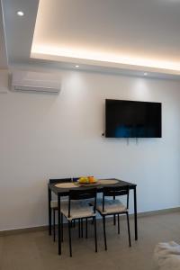a black table with chairs and a television on a wall at Vista Mare Suites in Kithnos