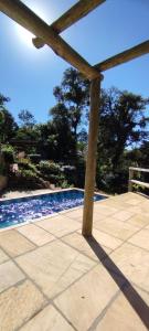 a view of a swimming pool with a pergola at Tiny House II - experiência de refúgio exclusivo in Gravataí