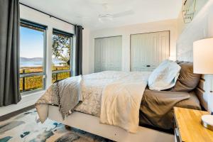 a bedroom with a large bed and a large window at On the Waterfront in Fish Haven