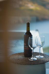 a bottle of wine and two glasses on a table at Vista Mare Suites in Kithnos
