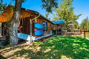 a log cabin with a tree and a house at On the Waterfront in Fish Haven