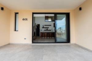 a room with a large glass door with a table at Modern 2BR Condo Close to Downtown Cabo in Cabo San Lucas